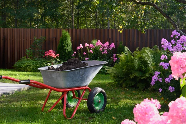 Wheelbarrow full of compost on yard — Stock Photo, Image