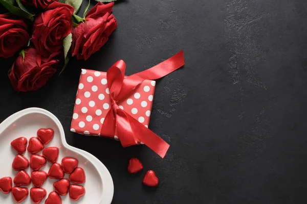 情人节礼物、巧克力糖果和黑色背景的红玫瑰. — 图库照片