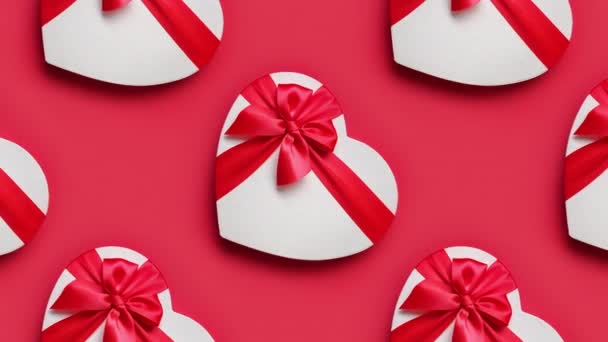 Valentijnsdag hart geschenken vergroten op rode achtergrond. — Stockvideo