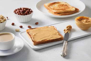 Beyaz masada fıstık ezmeli sağlıklı kahvaltı için tost. Kapat..