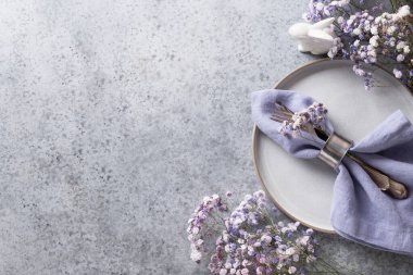 Tavşanlı Paskalya menekşesi masası ve gri masanın üstünde şenlik dekoru. Üst Manzara. Metin için boşluk.