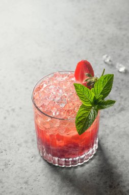 Çilekli taze kokteyl, püre, soda, limonata, buz küpü ve limon..