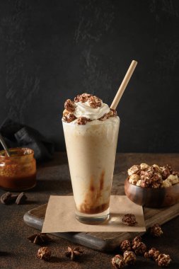 Muz ve karamel milkshake Süslenmiş krema ve patlamış mısır.
