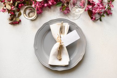 Beyaz masanın üzerinde çiçek açan elma çiçekleri olan zarif masa ayarı.