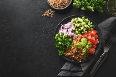 Mısır gevreği pişirilmiş siyah arka planda mevsimlik sebzeli salata..