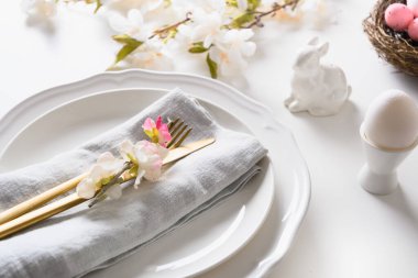 Beyaz masada çiçek açan Paskalya sofrası.