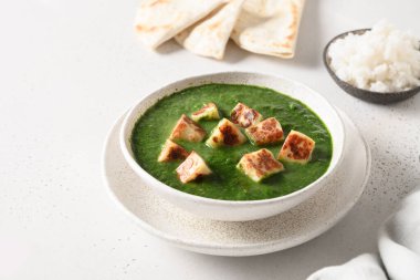 Palak Paneer beyaz arka planda basmati pilavı servis etti.