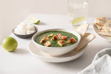 Palak Paneer beyaz masada basmati pilavı servis etti..