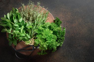 Ev yapımı maydanoz, nane, kekik, kahverengi arka planda biberiye. Yukarıdan bak. Boşluğu kopyala.