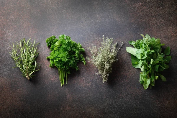 Homegrown fresh parsley, mint ,thyme, rosemary on brown background. View from above.