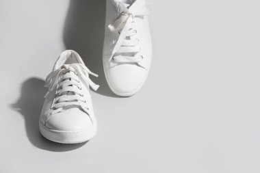 Gri arka planda beyaz kadın ayakkabıları.