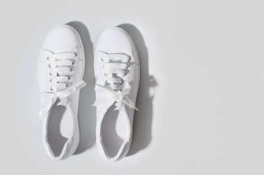 Sarı üzerine bir çift beyaz kadın ayakkabısı. Düz konum, üst görünüm minimum arkaplan. Dergi konsepti.