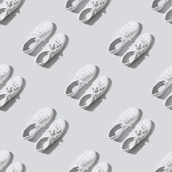 Nahtloses Muster weißer weiblicher neuer Gummischuhe auf grauem Hintergrund. Lässiges Outfit. — Stockfoto