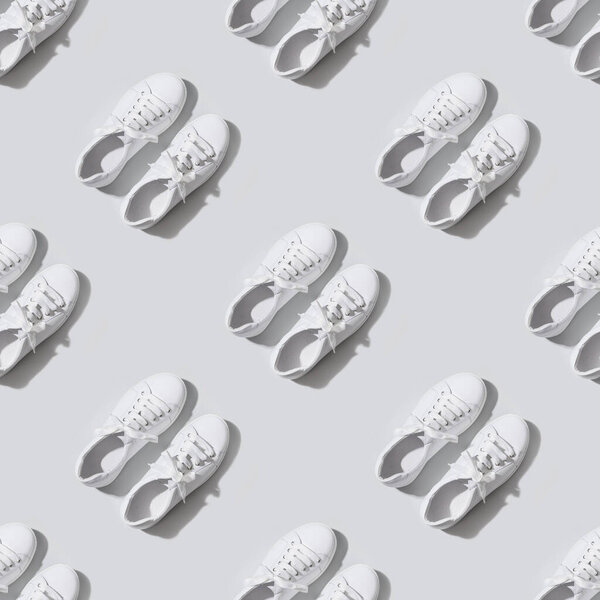 Seamless pattern of white female new gumshoes on grey background. Casual outfit.