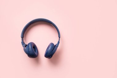 Pembe arka planda fotokopi alanı olan mavi kablosuz kulaklık. Yukarıdan görüntüle.