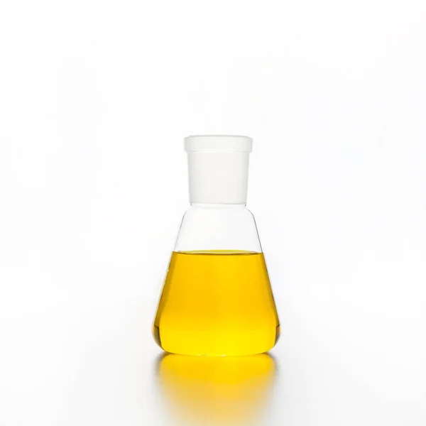 Chemistry flask with transparent yellow liquid for science research and experiment.