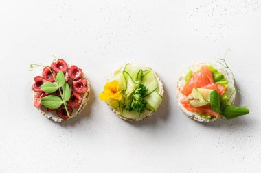 Farklı sebzeler, böğürtlenler ve beyaz arka planda kırmızı balıklı pirinç gevreği. Düz yatıyordu. Yukarıdan bak. Sağlıklı yiyecek..