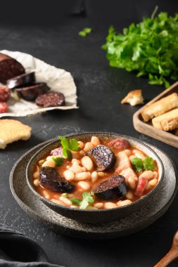 İspanyol asturiana fabada 'sı siyah masada. Kapat..