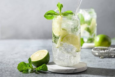 Limonlu taze mojito, nane şekeri, gri arka planda buz küpü. Kapatın. Yaz popüler içeceği.