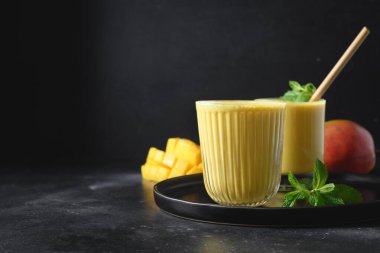 Siyah arka planda Hint mangosu veya zerdeçal lassi