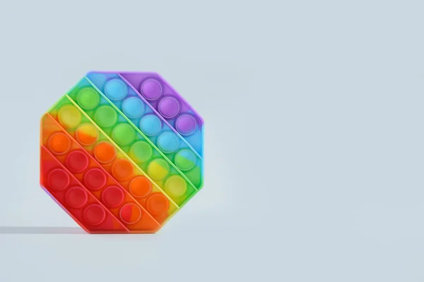 Zabawny silikon kolorowy antystres pop to zabawka na szary . — Zdjęcie stockowe