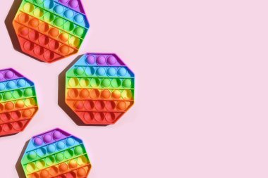 Birçok popüler silikon duyusal anti-stres, pembe arka plandaki çocuklar için oyuncak olarak kullanılıyor. Yukarıdan bak. Uzayı kopyala Pop Bubble 'a bas.