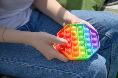 Kız silikon anti stres oyuncağıyla oynar Altıgen şeklindeki oyuncakla patlatır.
