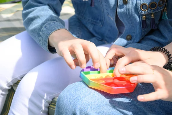 Ragazze che giocano con popolare silicone antistress pop it giocattolo esagonale. — Foto Stock