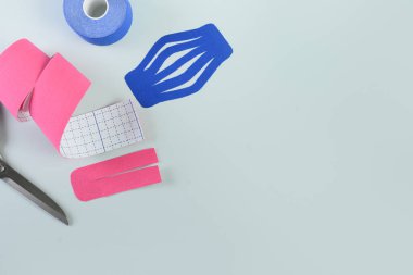 Mavi arkaplandaki uygulama için kineziyoloji bandını sarıyor.