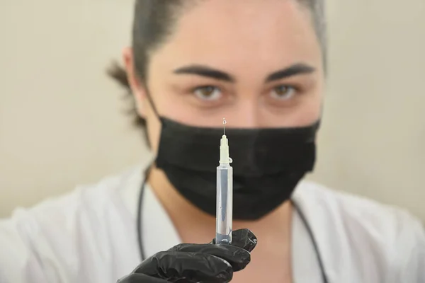 El médico sostiene y prepara una jeringa para la inyección de belleza. Mujer caucásica — Foto de Stock