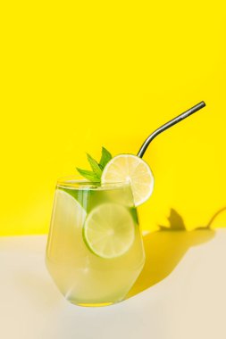 Limonlu yaz limonatası ve sarı, güneşli arka planda nane. Kapat..