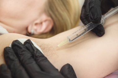 Doktor elektroliz işleminden önce koltukaltına anestezi enjekte eder.