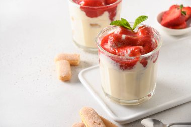 Cam kavanozlarda katmanlı çilek tatlısı Savoyardi, beyaz mascarpone.