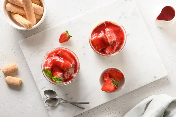 Postre en capas en frascos de vidrio con galletas savoyardi, mascarpone y crema batida decorado fresas — Foto de Stock