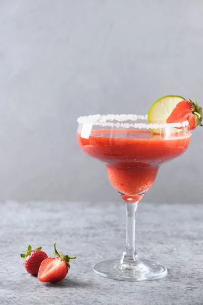 Erdbeer-Margarita-Cocktail mit Limettensaft und Eiswürfel auf schwarzem Hintergrund. Vertikale Orientierung. — Stockfoto