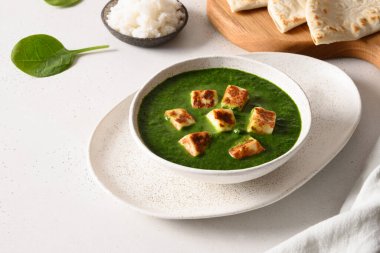 Palak Paneer beyaz üzerine basmati pilavı servis etti..