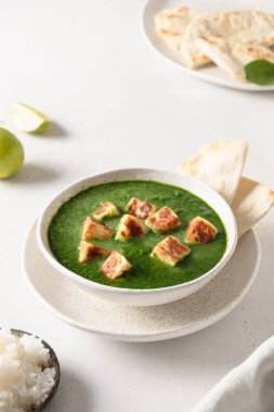 Palak Paneer beyaz arka planda basmati pilavı servis etti.