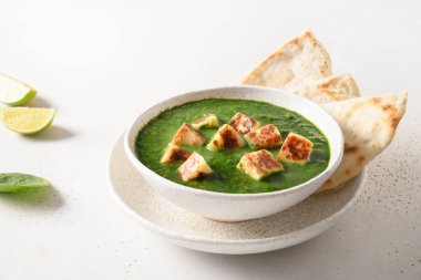 Palak Paneer beyaz üzerine basmati pilavı servis etti..