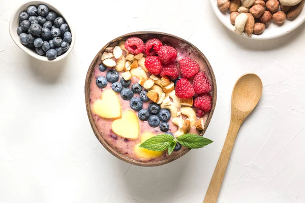 Desayuno saludable de plátano y batido de arándanos decorado con frutas en un bol de coco. — Foto de Stock