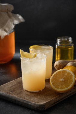Ev yapımı Kombucha. Şişede lezzetli içecek ve limonlu garnitürlü bardak..
