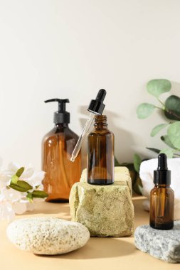 Nötr bej arka planda doğal kozmetik ürünleri ve gölgeli örtülü minimum kozmetik ürünleri