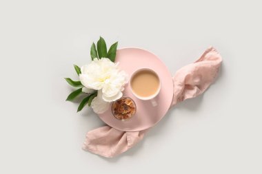 Kahve fincanı ve gri ofis masasında beyaz şakayık çiçekleri olan romantik yaz kahvaltısı..