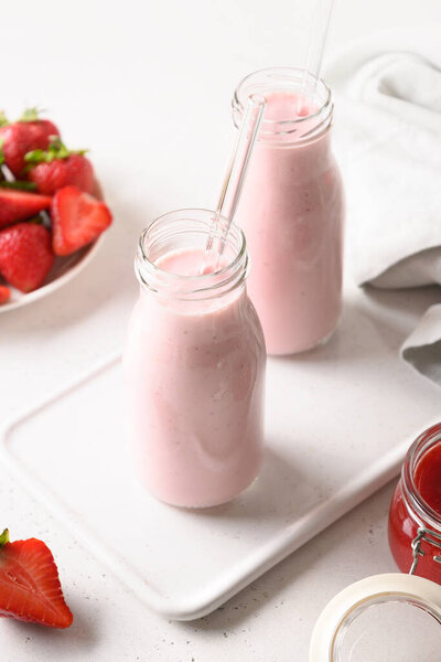Indian strawberry lassi or milkshake in bottle on gray.
