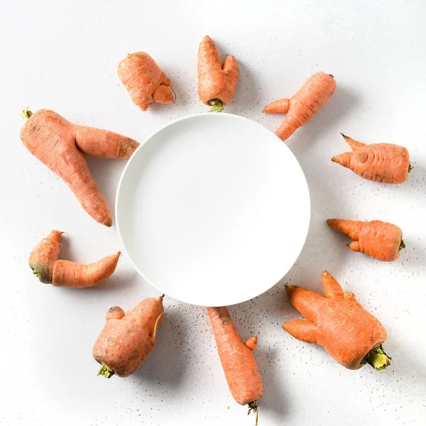 Zanahorias de cosecha propia inusual forma fea plato blanco con espacio para el texto. — Foto de Stock