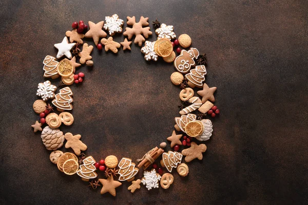 Corona de Navidad de galletas surtidas, canela, estrellas de anís, bayas, chips de naranja, ramas de abeto. —  Fotos de Stock