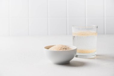 Beyaz masadaki bağırsaklar için psilyum kabuğu ve bir bardak suda çözünebilir lif..