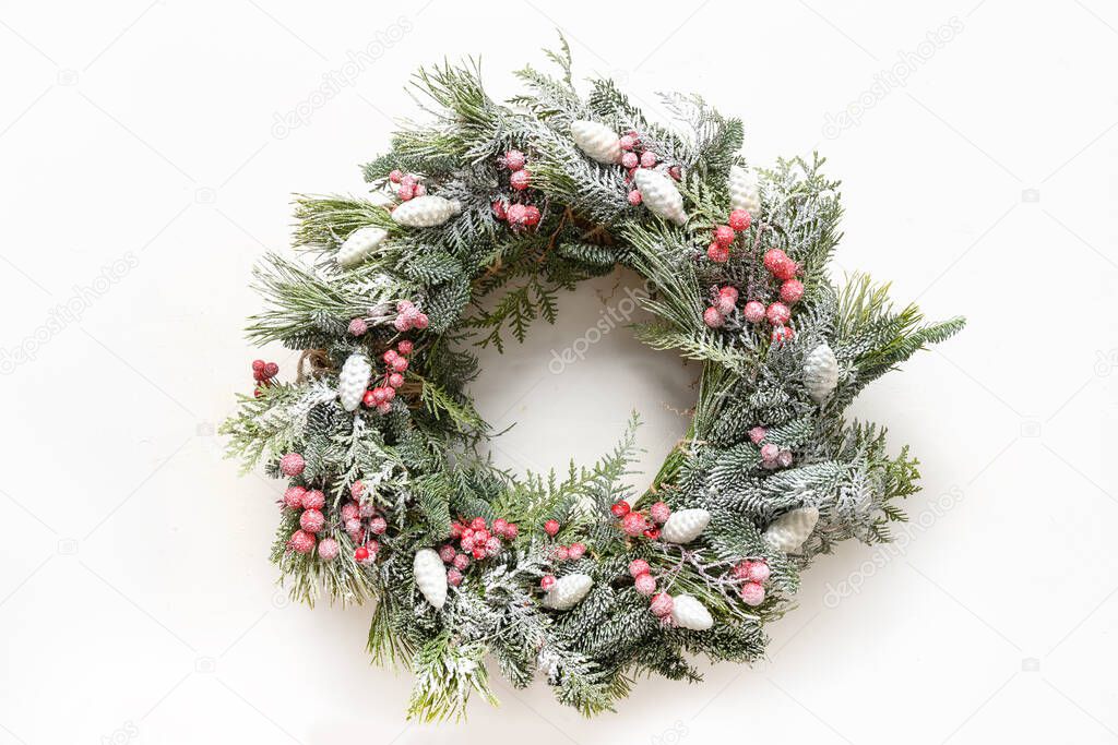 Christmas wreath of fresh natural spruce branch with red decoration on white background. New Year. Xmas holiday.