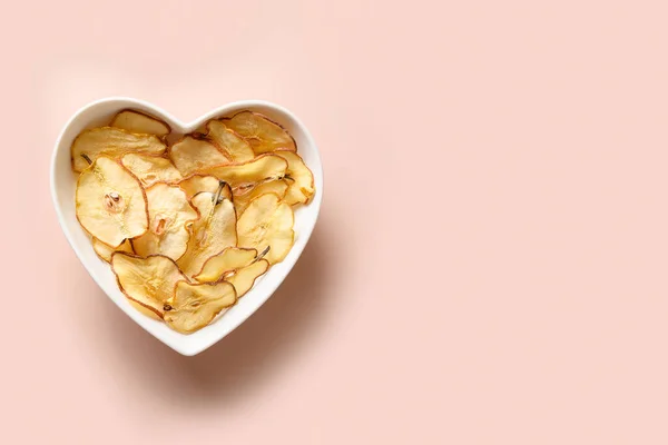 Gyümölcsök körte chips lemez alakú szív rózsaszín alapon. — Stock Fotó