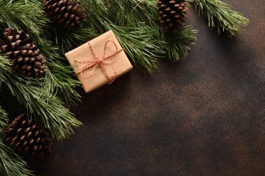 Hediye ile Noel sınırı ve kahverengi arka planda her daim yeşil dallar. Üst Manzara. Xmas Noel tebrik kartı. Uzayı kopyala Yeni Yıl.