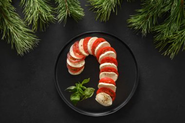 Noel 'de Caprese şeker kamışı bayramı aperatifleri siyah arka planda sunuluyordu. Üst Manzara. Xmas şenlik partisi.